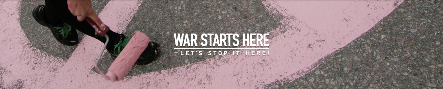 En roller målar rosa fredstecken på asfalt. War Starts Here's logotyp.